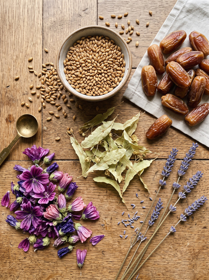 Ingrédients d'AGHRUM : orge, dattes, tilleul, mauve et lavande sur une table en bois